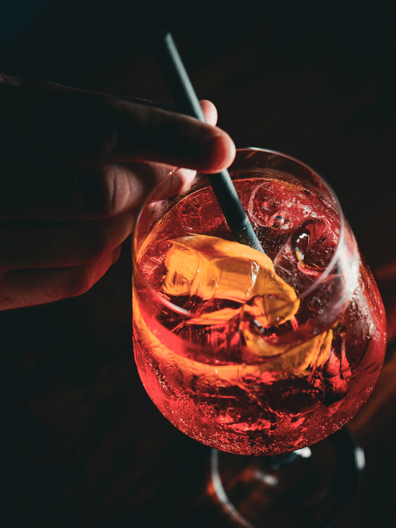 A red cocktail being stirred at the bar
