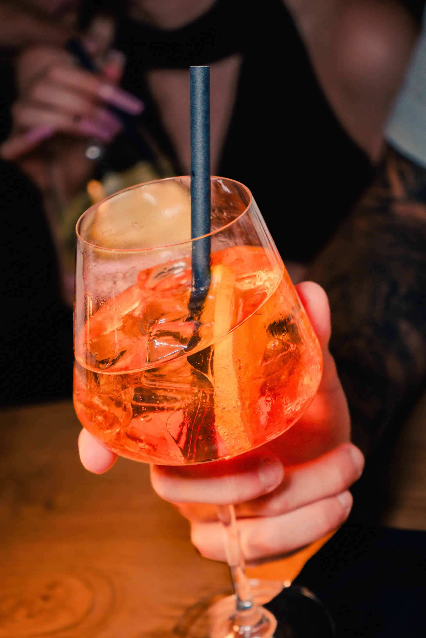 An orange spritz held over the bar